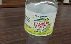 a bottle of lemon water sitting on top of a wooden table