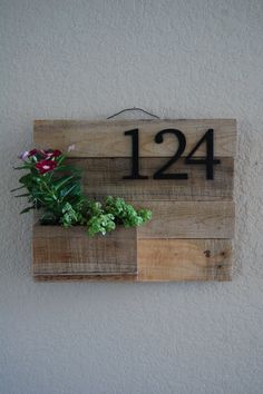 a wooden sign with plants in it and the number twenty four