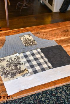 a wooden table topped with different types of fabric