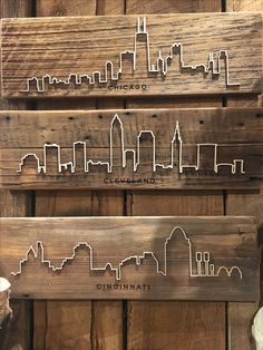 three wooden signs with city skylines on them