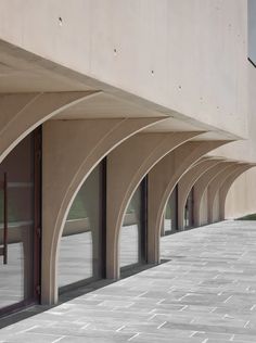 an empty building with arched windows on the outside and brick walkway in front of it