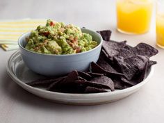 a bowl of guacamole and tortilla chips on a plate