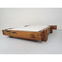 a bed frame made out of wood with white sheets on the top and bottom part