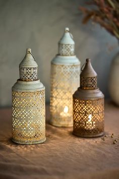 three decorative lanterns sitting on top of a table