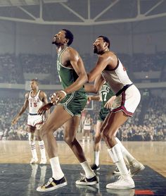 two men playing basketball in front of an audience