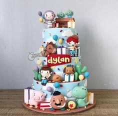 a three tiered cake with cartoon characters on it