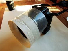 a camera with a roll of toilet paper on it's side sitting on a table