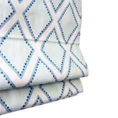 two blue and white patterned sheets on top of each other