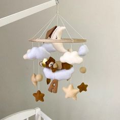 a baby crib mobile with a teddy bear on the moon and stars hanging from it