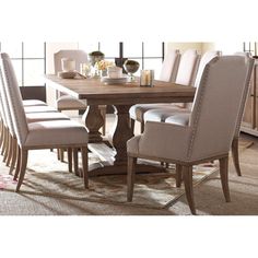 a dining room table with beige chairs around it