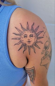 a woman with a sun tattoo on her shoulder