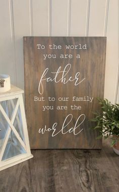 a wooden sign that says to the world you are a father but to our family you are the world