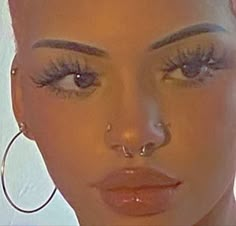 a close up of a woman with large hoop earrings on her head and wearing fake eyelashes