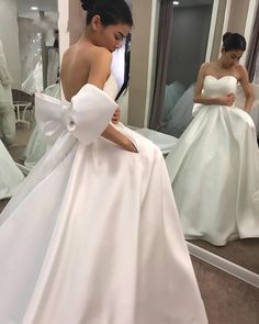 a woman in a wedding dress looking at her reflection