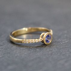 This stunning 14k yellow gold diamond and tanzanite ring features a round cut bezel set Tanzanite with a beaded detail around the setting. Accented with 6 round cut diamonds on either side, this is a beautiful one of a kind gem! Stone Significance:Tanzanite is commonly believed to facilitate a higher consciousness and stimulate intuition and perception. ⊹ Recycled 14K Yellow Gold, Diamond + Tanzanite⊹ Stamp reads 14k⊹ Excellent vintage, upcycled condition with the exception of surface scratches Tanzanite Diamond Ring With Accents, Tanzanite Diamond Ring With Diamond Accents, Tanzanite Ring, Higher Consciousness, Gem Stone, Jewelry Inspo, Beautiful One, Round Cut Diamond, Bezel Setting