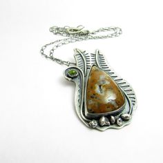 "A unique and one of a kind pendant necklace featuring a fern design with a peridot and an earthy druzy agate. Inspired by the raw beauty of the agate, the deep brown tones, flecks of black and crystalline magic at it's heart--A piece was born, and invocation of primordial mineral and organic energy, the essence of life. Hand crafted from argentium sterling silver, agate and peridot. Layers of pierced and textured sterling silver provided the depth and contrast in the metal, with additions of st Earthy Sterling Silver Jewelry With Natural Stones, Nature-inspired Teardrop Gemstone Necklace, Earthy Moss Agate Jewelry As Gift, Nature-inspired Necklace With Natural Stones, Earthy Gemstone Pendant Jewelry, Earthy Moss Agate Jewelry Gift, Nature-inspired Gemstone Teardrop Pendant Necklaces, Earthy Moss Agate Jewelry With Natural Stones, Nature-inspired Gemstone Pendant Necklace