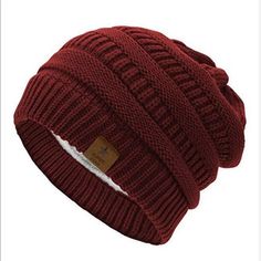 a red knitted beanie hat with a label on the front and bottom side