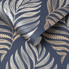 a blue and gold wallpaper with silver leaves on the back drop in front of it