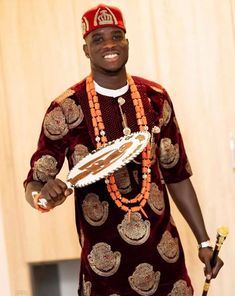 a man in a red and gold outfit holding a cake