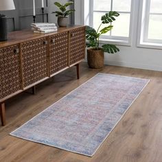 a living room area with a rug on the floor and a large window in the background