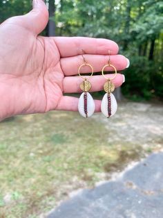 These cowrie shell beaded earrings are gorgeous. They look good with any outfit. They are one of kind and unique.  They are delicately designed with cowrie shells, brass spiral beads, and accented with red miyuki Picasso beads, with brass french hook ear posts These earrings come to you in a white box ready for gift giving Please note colors may vary from picture, and it is advised to not wear in water or get wet. Your satisfaction is my first priority. If you are not happy with your purchase fo Handmade Seashell Jewelry, Bohemian Shell Dangle Earrings, Bohemian Dangle Shell Earrings, Beach Jewelry With Teardrop Dangling Beads, Teardrop Dangling Beads Jewelry For Beach, Beach Teardrop Jewelry With Dangling Beads, Bohemian Shell Earrings For Jewelry Making, Handmade Shell Bohemian Hoop Earrings, Bohemian Handmade Shell Hoop Earrings