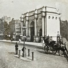 an old black and white photo of a horse drawn carriage in front of a building