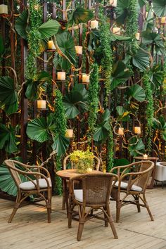 an outdoor dining area with chairs, tables and plants on the fenced in wall