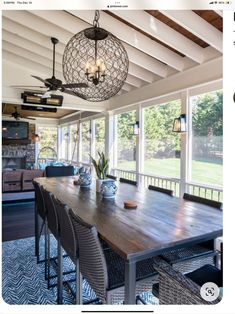 an image of a dining room table with chairs and chandelier hanging from the ceiling