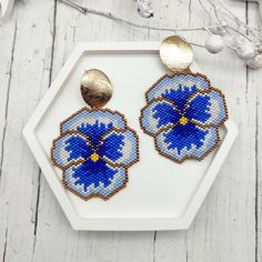 These elegant "Pansy Flower" earrings are handcrafted from high-quality Japanese beads. Each piece is created from my unique beadwork pattern. Inspired by the delicate pansy flowers, the earrings are crafted in shades of cornflower blue with accents of white and gold. Large 18K gold-filled oval studs add luxury and elegance to these accessories. These earrings will be a perfect addition to your outfit, highlighting your individuality and taste Materials: Japanese beads, 18K gold-filled studs Col Blue Handwoven Beaded Earrings For Gift, Handwoven Blue Beaded Earrings For Gift, Blue Flower Earrings With Colorful Beads As Gift, Blue Flower Beaded Earrings For Gift, Gift Blue Flower Earrings With Colorful Beads, Blue Flower Shaped Beaded Earrings, Blue Flower-shaped Earrings With Colorful Beads, Blue Flower-shaped Beaded Earrings, Blue Flower Beaded Earrings