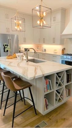 a large kitchen with an island and bar stools