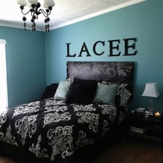 a bed room with a neatly made bed and a chandelier