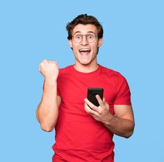 a man in red shirt holding a smart phone and raising his fist up with both hands