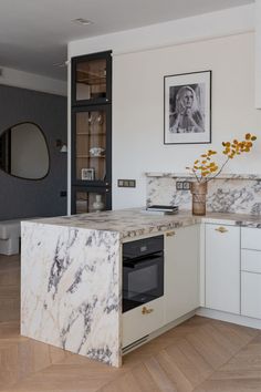 a kitchen with marble counter tops and white cabinets