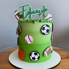 a green birthday cake decorated with sports balls