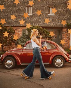 a woman walking past a red car with stars on the roof and in front of it