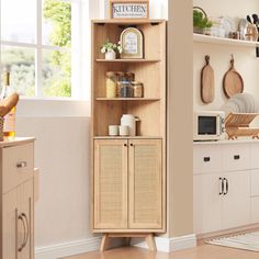 a kitchen area with a microwave, cabinets and other items on the shelves in front of a window