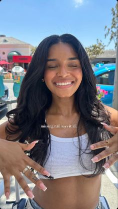 a woman is smiling and holding her hands up