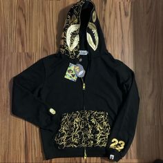 Authentic Bape 23rd Anniversary Gold-Themed Limited Edition Collection Hoodie Brand New With Tags Size M Luxury Long Sleeve Hoodie For Fall, Luxury Hooded Sweatshirt For Fall, Luxury Hooded Fall Sweatshirt, Luxury Long Sleeve Hoodie With Double-lined Hood, Luxury Hoodie With Drawstring Hood For Streetwear, Luxury Winter Hoodie Sweatshirt, Luxury Hooded Jacket With Double-lined Hood, Luxury Sweatshirt With Drawstring Hood For Streetwear, Luxury Drawstring Hood Sweatshirt For Streetwear