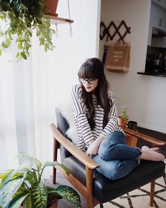 a woman sitting in a chair with her legs crossed