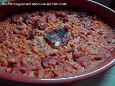 a red dish filled with meat and beans