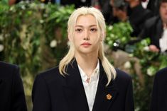 a woman with blonde hair standing between two other women wearing black suits and white shirts