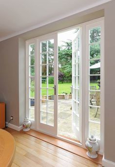 an empty living room with french doors leading to the back yard and deck area,