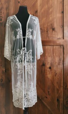 "An overlayering piece made with soft embroidered sheer lace. Makes for a super sweet cover up for any outfit! ONE SIZE FITS MOST - SMALL, MEDIUM, LARGE, XL Length: 46\" Bust: 24\" flat measure (tie front, one size fits all) Armhole: 14\" Get two items or more and your shipping is on us! Enter code FREESHIP at checkout! (US shipping only)" Bohemian Lace Beach Cover-up, White Lace Cover-up For Spring, Sheer Lace Beachwear Cover-up, White Fitted Long Cover-up, Bohemian Fitted Sheer Cover-up, White Wrap Cover-up For Spring, White One Size Open Front Cover-up, White Lace Trim Kimono For Wedding, Festival Open Front Cover-up