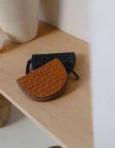 two small purses sitting on top of a wooden shelf