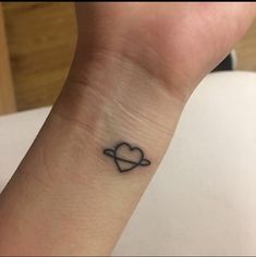 a small heart tattoo on the wrist