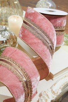 two pink and gold ribbons are sitting on a table