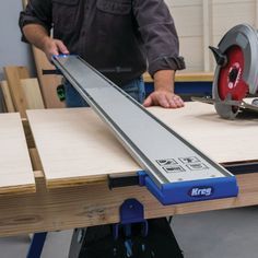 a man using a circular saw to cut plywood planks on a table top