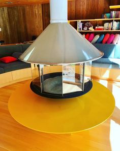 a lamp sitting on top of a wooden floor next to a book shelf filled with books