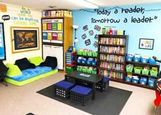 a classroom with bookshelves, desks, and couches in the corner