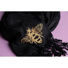 a black scarf with a gold bee on it